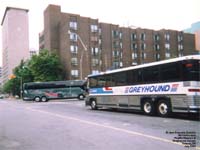 Pacific Western Prevost Serie H coach turns in front of a parked Greyhound Canada MCI.